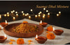 Dollop of Saamai Dhal Mixture on a wooden plate with decorative elements and lights in the background.
